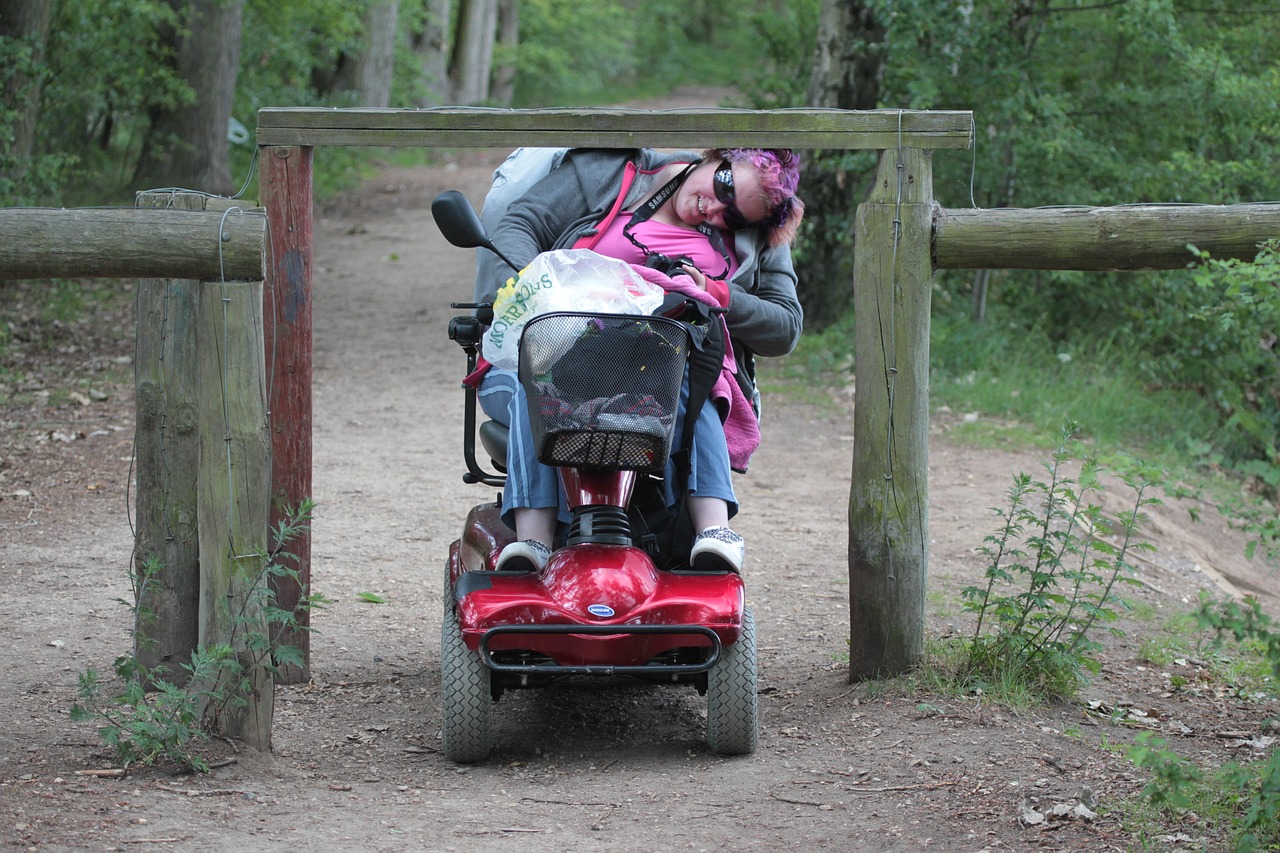 Ein Frau fährt mit dem Rollstuhl unter einem Geländer durch.